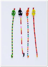 three different colored beads with faces on them and one has a cat's head in the middle