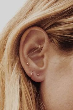 a close up of a person with ear piercings on their ears and behind the ear