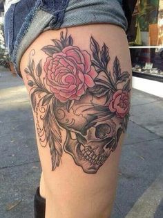 a woman's thigh with a skull and roses on it