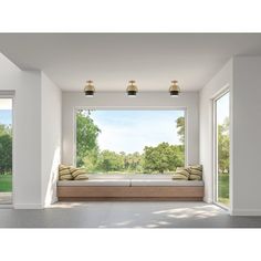 an empty room with two windows and a bench in the middle, overlooking a park