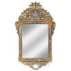 an ornate gold framed mirror hanging on the wall