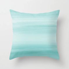 an ocean scene with blue, green and white watercolors on a pillow cover