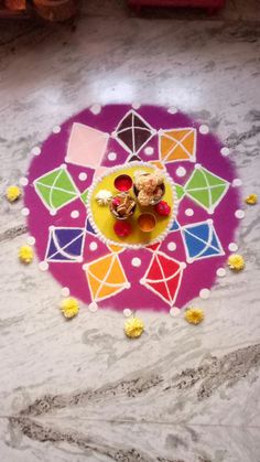 a colorfully decorated table with two small cakes on it and confetti in the middle