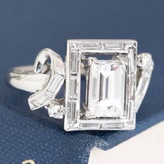 an emerald cut diamond ring on top of a book