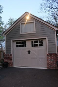 a garage with the sun shining on it's roof and windows in front of it