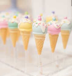 small ice cream cones with sprinkles on them are lined up in a row