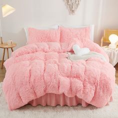 a bed with pink fluffy comforter and pillows