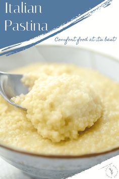 a spoon in a bowl filled with mashed potatoes on top of a white table