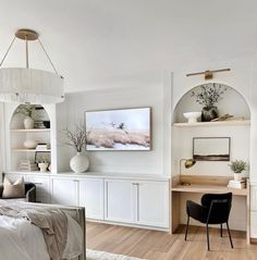 a bedroom with white walls and wood flooring, built - in shelving units