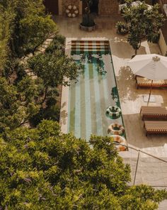 an aerial view of a swimming pool with lounge chairs and umbrellas