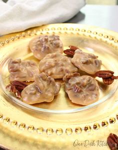 some pecans are sitting on a gold plate