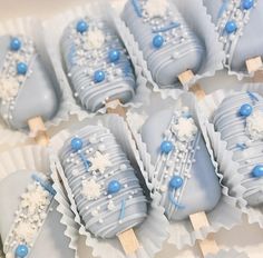 blue and white desserts are arranged in rows on a tray with toothpicks