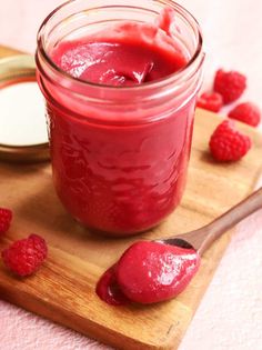 raspberry sauce in a jar with spoon on cutting board