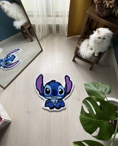 a small blue and purple cartoon character is on the floor next to a mirror