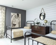 a bedroom with two twin beds and a painting on the wall above them, along with a dresser