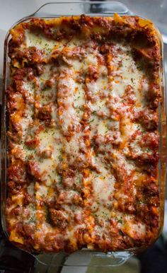 a casserole dish with meat, cheese and sauce in it sitting on a table