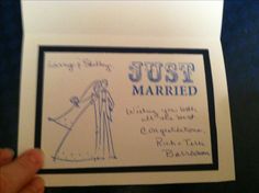 a hand holding up a wedding card with the words just married written on it and an image of a bride and groom