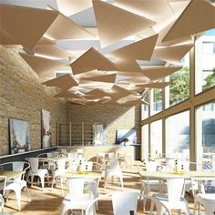 the interior of a restaurant with tables and chairs, hanging paper umbrellas over them