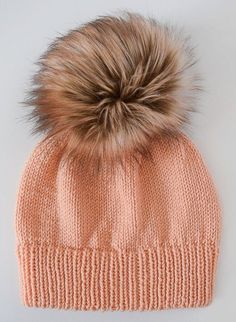 an orange hat with a brown fur pom