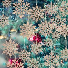 a christmas tree with snowflakes and baubles on it's branches