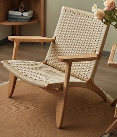 a wooden rocking chair sitting on top of a rug next to a vase with flowers