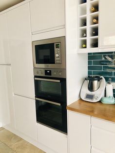 a kitchen with white cabinets and stainless steel appliance, including an oven and coffee maker