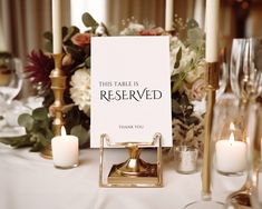 there is a sign that says this table is reserved with candles and flowers in the background