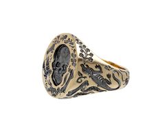 This edgy, hand engraved Castro Smith signet ring has a bold vibe and eye-catching design. The 9K yellow gold band has been carved with bones, skeletons, frogs and leaves. The round ring face has a detailed surface with leaves, spiders, bones and one large skull at its center. Each engraved part has been plated in black rhodium. A tiny engraved flower sits on the inside of the band for a secret for only the wearer. ring face : 3/4" x 5/8"9K yellow gold and black rhodium plated band width : 5mmsize available : 10please contact us for sizing options Castro Smith, Daniela Villegas, Digby And Iona, Rebecca Overmann, Pippa Small, Engraved Flower, Zoe Chicco, Cathy Waterman, Single Stone