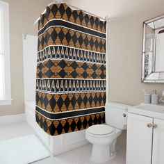 a bathroom with a black and gold shower curtain next to a white toilet in front of a mirror