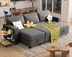 a living room with a gray couch and yellow throw pillows on the back of it