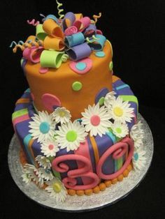 a birthday cake decorated with flowers and ribbons