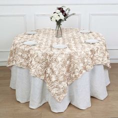 a table topped with a vase filled with white and red flowers sitting on top of a hard wood floor