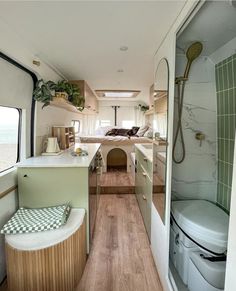 the inside of a camper with wood flooring and green tile on the walls