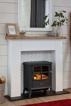 a fireplace with a wood burning stove in the center and a mirror above it on top of a mantle