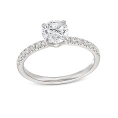 a white gold engagement ring with diamonds on the band and an oval cut diamond in the center