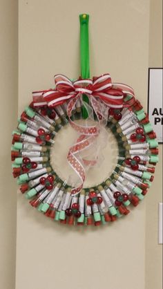 a christmas wreath made out of wine bottles and candy canes hangs on the wall