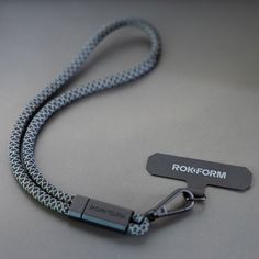 a black and silver lanyard with a hook for the name rokoformm on it