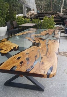 a table that is made out of wood and glass with black metal legs on it