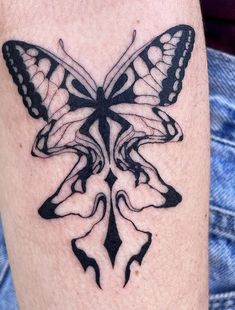 a black and white butterfly tattoo on the left leg, it appears to be an intricate design