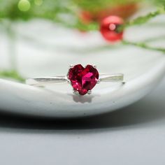 A sweet alternative to the ever-popular classic solitaire, this Sterling Silver Ruby Heart Ring features a 6 mm heart shaped lab grown ruby. The stone is securely held in a 6-prong sterling silver mounting. We are happy to create this engagement ring for you in a variety of sizes, stone choices, and finish options. For the Ring: This Sterling Silver ring features a sparkling 6 mm (approximately 1 carat) heart-shaped stone. The six-prong mounting securely holds and protects this unusual stone. Th Heart-shaped Solitaire Birthstone Ring Gift, Valentine's Day Ruby Birthstone Ring With Round Cut, Valentine's Day Gift Birthstone Ring With Round Cut, Valentine's Day Proposal Ruby Birthstone Ring, Valentine's Day Solitaire Birthstone Ring Gift, Valentine's Day Round Cut Birthstone Ring With Prong Setting, Valentine's Day Birthstone Ring With Round Cut Prong Setting, Dainty Heart-shaped Birthstone Ring For Valentine's Day, Valentine's Day Promise Ruby Ring With Prong Setting