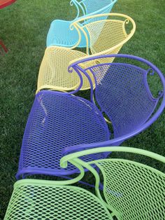 colorful chairs are lined up on the grass