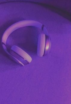 a pair of headphones sitting on top of a purple surface