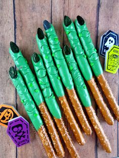 some green and brown sticks on top of a wooden table with halloween decorations around them