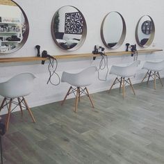 a row of white chairs sitting next to each other on top of a hard wood floor