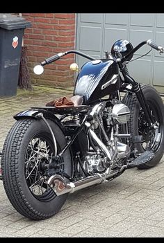 a black motorcycle parked in front of a garage