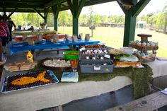 an outdoor picnic area with food on the table