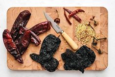 an assortment of vegetables on a cutting board with a knife and peppercorst next to it