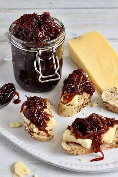 jam and cheese are spread on toasted bread with jelly in a jar next to it