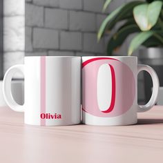 two coffee mugs sitting on top of a wooden table