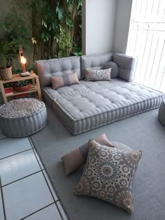 a living room filled with lots of furniture next to a large window and potted plants